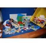 A yellow tub of Lego including transport trains, track, racing car, plane, etc.