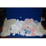 A quantity of vintage baby knitted clothes, crocheted shawl, plastic pants, tights, etc.