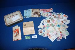 A tin of mixed English and foreign stamps.