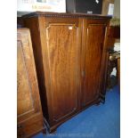 A gentleman's Mahogany Wardrobe having raised and fielded panelled doors revealing hanging space