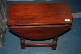 An oval Oak drop-leaf occasional Table, 18'' high.