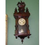 A dark wood cased wall clock with an eagle pediment and Acanthus leaf detail to the Roman style