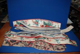 A quantity of curtain tie backs including floral and red, navy blue etc.