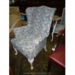 A wing fireside Chair upholstered in grey ground fabric depicting black-face sheep