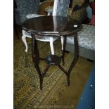 An Edwardian dark wood circular Occasional Table having legs united by a lower shelf,