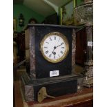 A black marble Clock with Roman numerals and key.