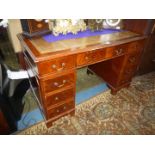 A contemporary Mahogany Kneehole double pedestal Desk having inset gold tooled brown leather top,