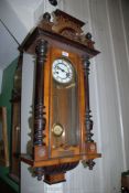 An Edwardian wall-clock with ebonised pillars and a presentation plaque dated 1924,