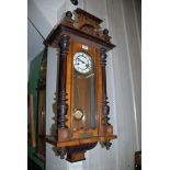 An Edwardian wall-clock with ebonised pillars and a presentation plaque dated 1924,