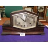 A dark Oak finished Art Deco style mantel Clock having a compressed hexagonal face with Arabic