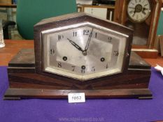 A dark Oak finished Art Deco style mantel Clock having a compressed hexagonal face with Arabic