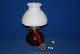 A red glass Oil Lamp with white shade, 13'' tall.