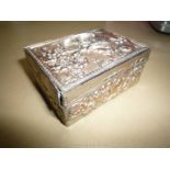 A plated metal trinket box having a hinged lid and decorated in chinoiserie style in relief with an