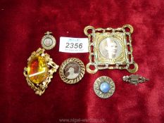 A small ornate brass picture frame, 2 1/2'' square, a brooch with picture of a young girl,