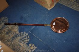 A copper bed warming pan