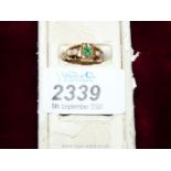 A boxed 15 ct Gold Ring set with a central green stone of vivid emerald colour and four small opals,