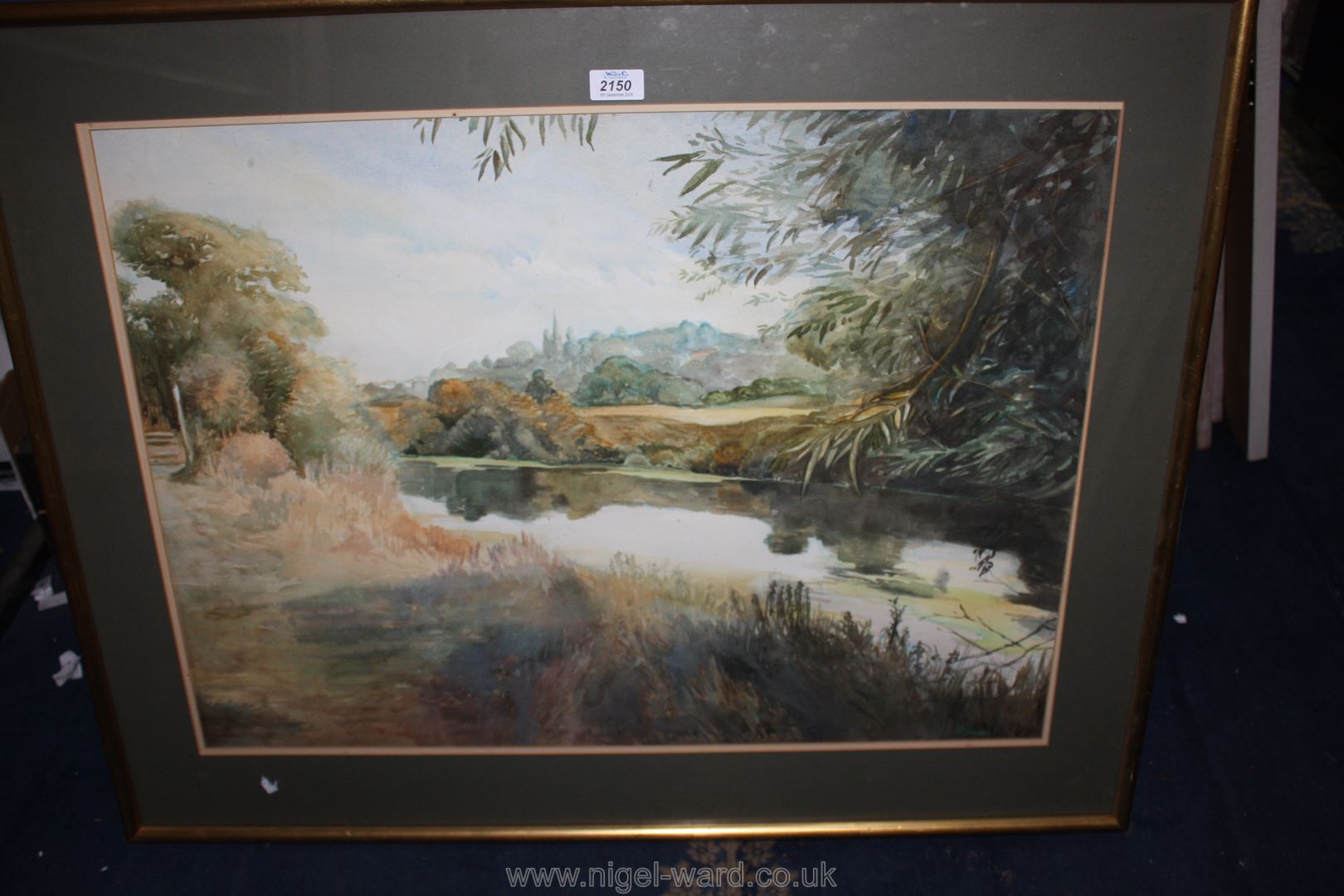 A large framed and mounted Watercolour of a river landscape with church spire in the distance