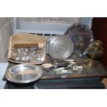 A quantity of plated ware, cutlery and serving dishes, brass oil lamp, table lamp etc.