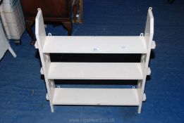 A painted set of wooden peg end shelves, 27" high x 26" wide x 6" deep.