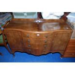 A bow fronted four drawer two cupboard sideboard.