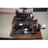 Two hand cranked sewing machines.