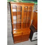A modern glazed display cabinet over two door cupboard,
