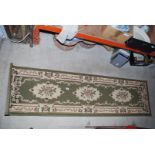 A green/ivory carpet runner, 2' x 86".