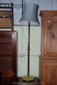 A brass standard lamp with shade.