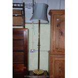 A brass standard lamp with shade.