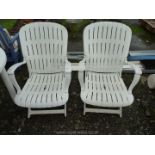 Two plastic adjustable patio chairs.