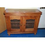 A hardwood pierced door cupboard, 43" long x 16" deep x 36" high.