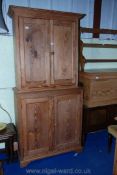 A pine kitchen cupboard with two shelves to the top and one and a half shelves to the bottom,