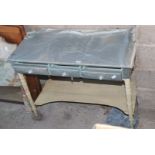 A three drawer covered side Table with lower tier,