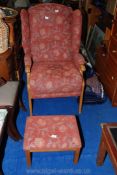 An upholstered armchair with matching stool.