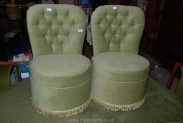A pair of green button back tub chairs.