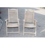Pair of weathered teak garden reclining chairs