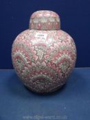 A large oriental ginger jar with embossed pink lotus pattern. 13" tall.