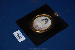 An antique Portrait Miniature in lacquered frame of a young woman in a satin dress,