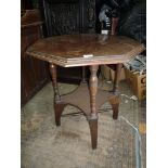 An Edwardian Mahogany octagonal Occasional Table standing on turned legs with a lower shelf and a