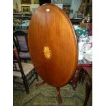 A circa 1900 oval snap-top Table having boxwood stringing and central inlaid boxwood stylised