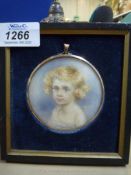 A rectangular framed, circular Portrait miniature of a young blue eyed child with golden locks,