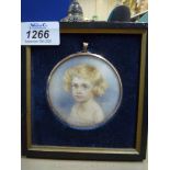 A rectangular framed, circular Portrait miniature of a young blue eyed child with golden locks,