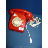 A vintage red dial telephone.