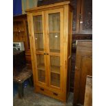 A mid Oak floor standing display/storage Cupboard having a pair of opposing two pane doors over a