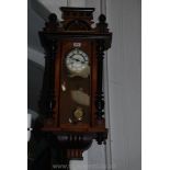 An Edwardian wall-clock with ebonised pillars and a presentation plaque dated 1924,