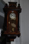 An Edwardian wall-clock with ebonised pillars and a presentation plaque dated 1924,