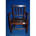 An antique Clisset type spindle back child's Armchair in ash with figured elm seat,
