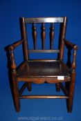 An antique Clisset type spindle back child's Armchair in ash with figured elm seat,