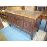 A peg joyned three panel Oak Coffer having later carving including scrolls and to the central panel