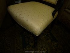 A circa 1900 ebonised framed, gold highlighted Nursing Chair having turned front legs,
